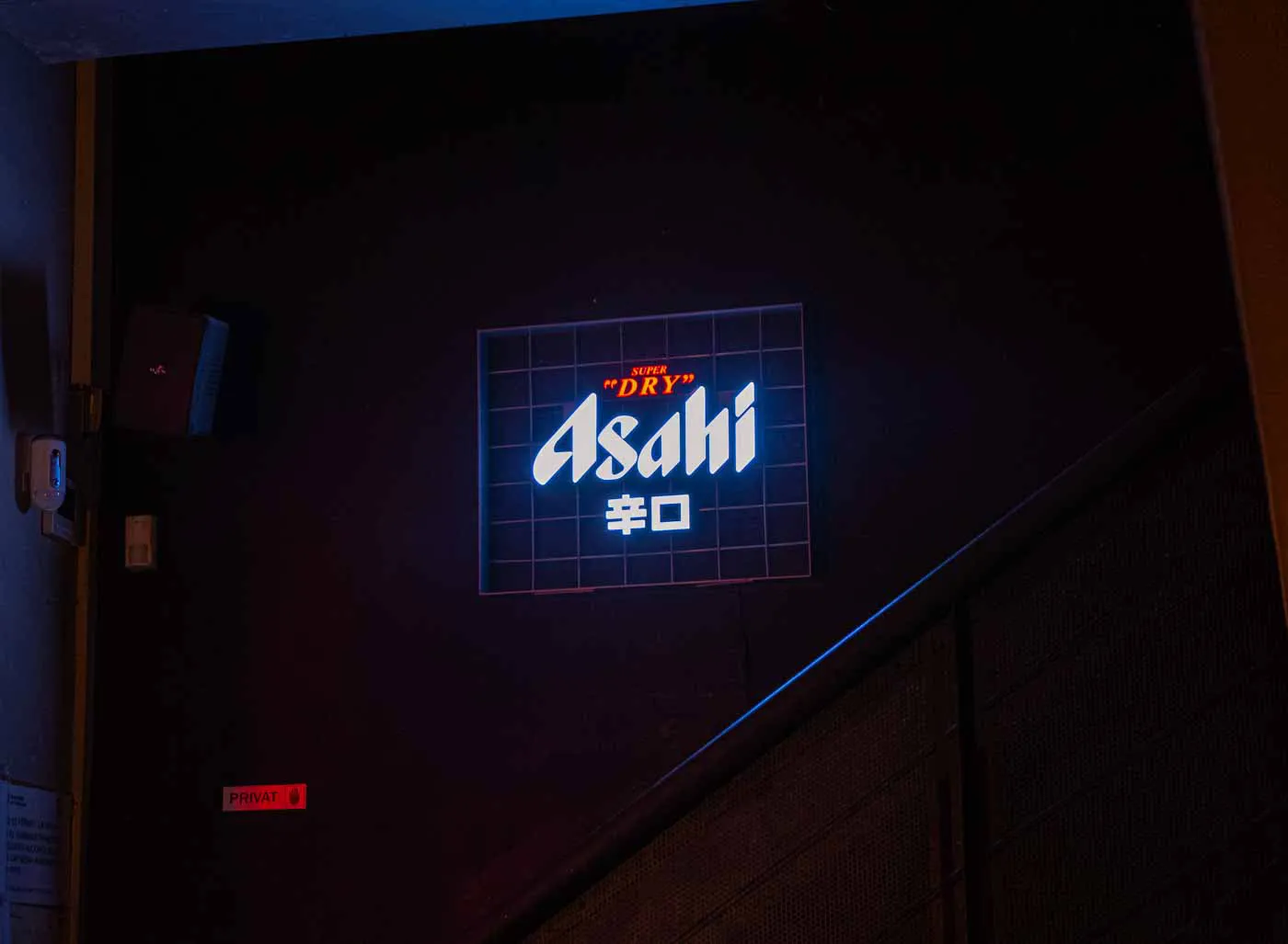 Un neó d'Asahi en una paret fosca de Koku Kitchen El Gòtic